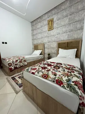a bedroom with two beds and a brick wall at Perfect Cozy Apartment in City Center Hamrya in Meknès