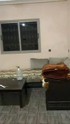 a room with a table and a couch and a window at Ourika in Aghbalou