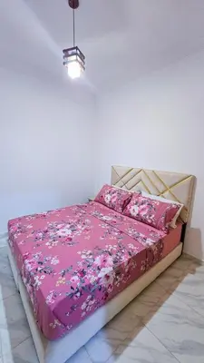 a bedroom with a bed with a pink comforter at Lovelystay in Fes in Fès