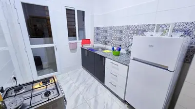 a white kitchen with a stove and a refrigerator at Lovelystay in Fes in Fès