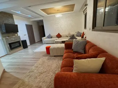 a living room with two couches and a tv at شقة جميلة ومجهزة افران in Ifrane