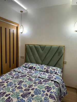a bedroom with a bed with a floral bedspread at شقة جميلة ومجهزة افران in Ifrane