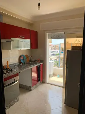 a kitchen with red cabinets and a counter top at martil in Oulad Akkou