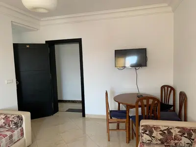 a room with a table and a television on the wall at martil in Oulad Akkou