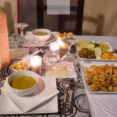 a table with plates of food and a bowl of soup at Bedouin House in Merzouga