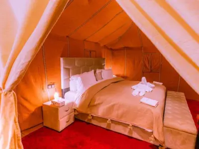a bedroom with a bed with a stuffed animal on it at Bedouin House in Merzouga