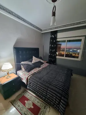 a bedroom with a bed and a window at Seaside Serenity 5 Star Flat By Train Station in Oulad Akkou