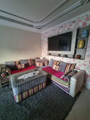 a living room with two couches and a flat screen tv at Seaside Serenity 5 Star Flat By Train Station in Oulad Akkou