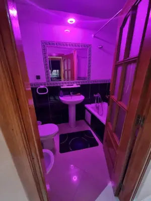 a purple bathroom with a toilet and a sink at Seaside Serenity 5 Star Flat By Train Station in Oulad Akkou