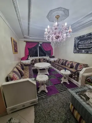 a living room with a couch and a chandelier at Seaside Serenity 5 Star Flat By Train Station in Oulad Akkou