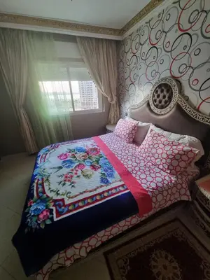 a bedroom with a bed with a quilt on it at Seaside Serenity 5 Star Flat By Train Station in Oulad Akkou