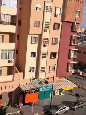 a tall building with cars parked in front of it at Apartment with beautiful view in the center of Marrakech in Oulad Akkou