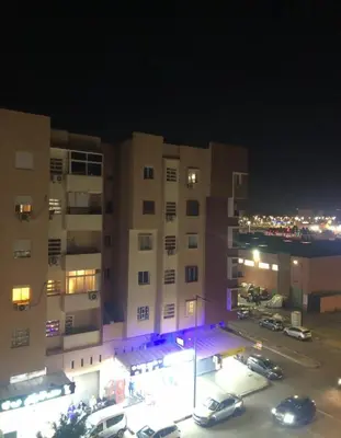 a building with cars parked in a parking lot at night at Apartment with beautiful view in the center of Marrakech in Oulad Akkou