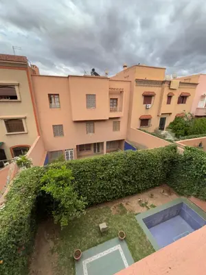 an ivy covered building with a pool in front of it at Belle Chambre Dans Une Villa in Oulad Akkou