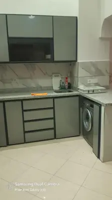 a kitchen with a stove and a washing machine at appartement complexe farah airoport in Oulad Akkou
