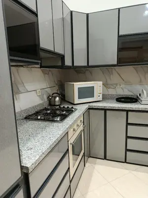 a kitchen with a stove and a microwave at appartement complexe farah airoport in Oulad Akkou