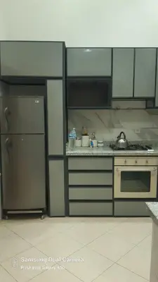 a kitchen with a refrigerator and a stove top oven at appartement complexe farah airoport in Oulad Akkou