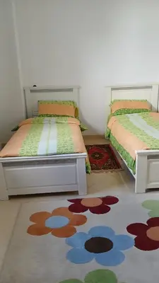 two beds sitting next to each other in a room at appartement complexe farah airoport in Oulad Akkou