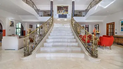 a spiral staircase in a home with a red chair at Villa Hiba Luxury & Paddle in Najem