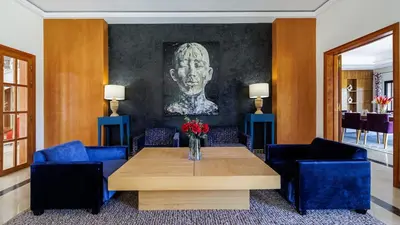 a living room with a table and blue chairs at Villa Hiba Luxury & Paddle in Najem