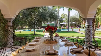 a table with plates and a vase of flowers on it at Villa Hiba Luxury & Paddle in Najem