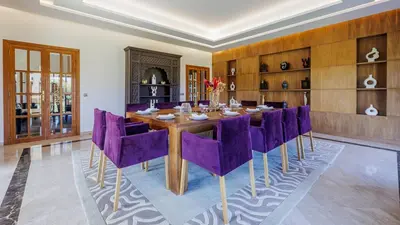 a dining room with a table and purple chairs at Villa Hiba Luxury & Paddle in Najem