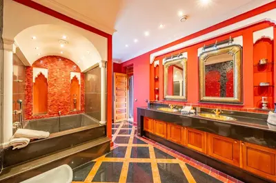 an orange bathroom with two sinks and a shower at Villa Hiba Luxury & Paddle in Najem