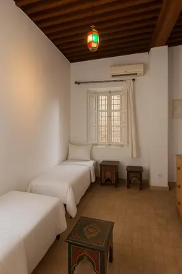 a room with three beds and a window at Dar Mohamadia in Fès
