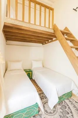 two beds in a room with a staircase at Dar Mohamadia in Fès