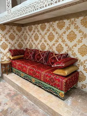 a red couch sitting in a room with a wall at Dar Mohamadia in Fès