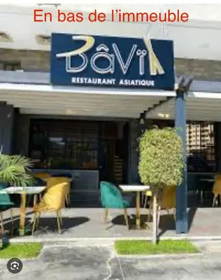 a restaurant with chairs and tables in front of a building at Appartement à proximité de tout ! in Fès
