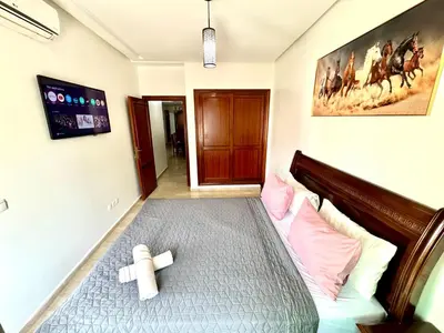 a bedroom with a bed with pink and white pillows at Appartement à proximité de tout ! in Fès