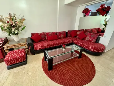 a living room with a red couch and a coffee table at Appartement à proximité de tout ! in Fès