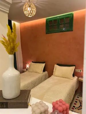 a room with two beds and a vase on a table at Chic accommodation in Moroccan style in Oulad Akkou