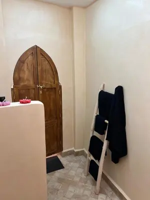 a room with a wooden door and a chair at Chic accommodation in Moroccan style in Oulad Akkou