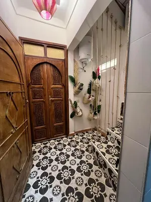 a hallway with a door and a black and white tile floor at Chic accommodation in Moroccan style in Oulad Akkou