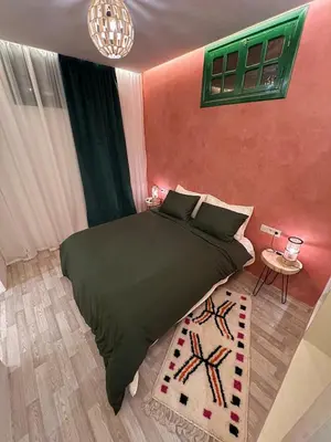 a bedroom with a black bed and a pink wall at Chic accommodation in Moroccan style in Oulad Akkou