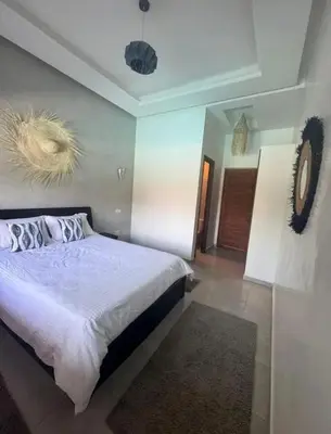 a bedroom with a bed and a clock on the wall at Villa Close to Lhdim Square in Meknès