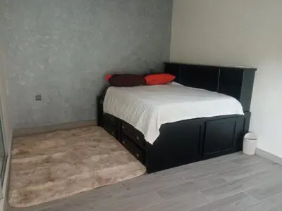 a bedroom with a bed with a red pillow on it at Villa Close to Lhdim Square in Meknès