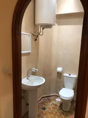 a bathroom with a white toilet and a sink at المغرب in Oulad Akkou