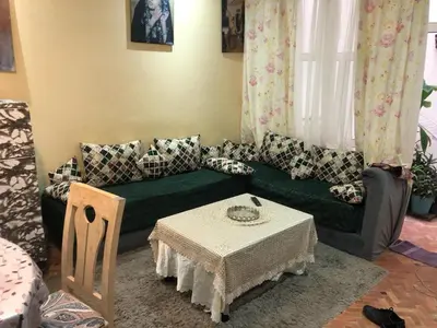 a living room with a green couch and a table at المغرب in Oulad Akkou