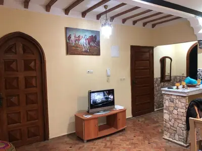 a living room with a tv on a table and a door at المغرب in Oulad Akkou