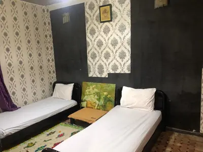 two beds in a room with black walls at المغرب in Oulad Akkou