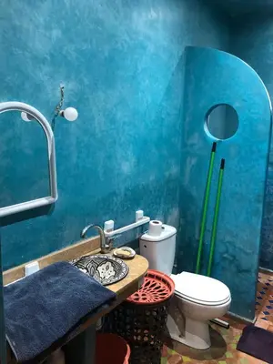 a bathroom with a toilet and a blue wall at المغرب in Oulad Akkou