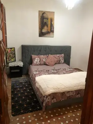 a bedroom with a bed with a head board at المغرب in Oulad Akkou