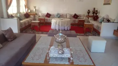 a living room with a couch and a table at Cosy villa in Oulad Akkou