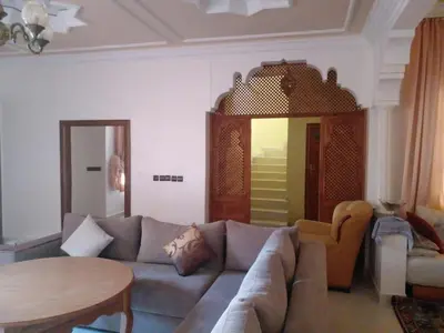 a living room with a couch and a table at Cosy villa in Oulad Akkou