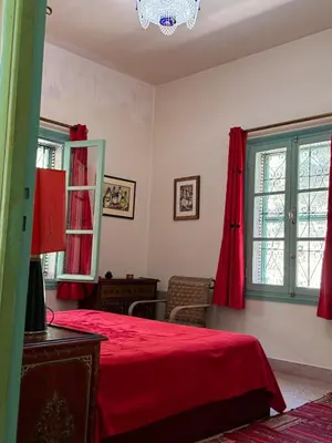 a bedroom with red curtains and a bed at Villa Zaïtoun in Aït Ourir