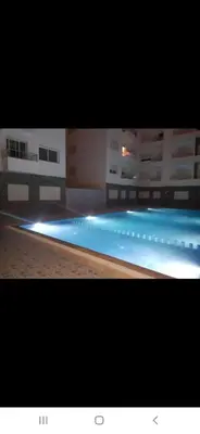 a large swimming pool with lights in a building at Appartement avec ,1 minte de la plage in Oulad Akkou