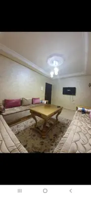 a living room with a table and a couch at Appartement avec ,1 minte de la plage in Oulad Akkou